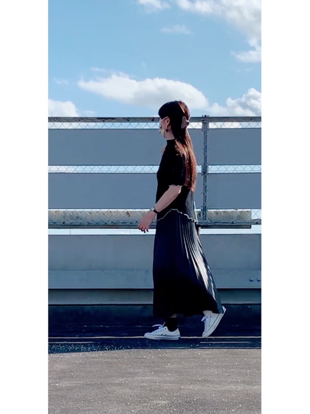 ブラック系のスカート、ホワイト系のスニーカー、ブラック系のショルダーバッグを着用したレディースの秋コーディネートの3枚目の写真