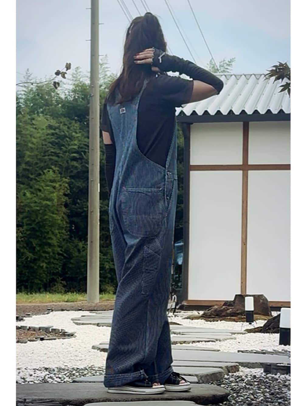 グレー系のTシャツ/カットソー、ブルー系のサロペット/オーバーオール、ブラック系のサンダルを着用したレディースの夏コーディネートの2枚目の写真