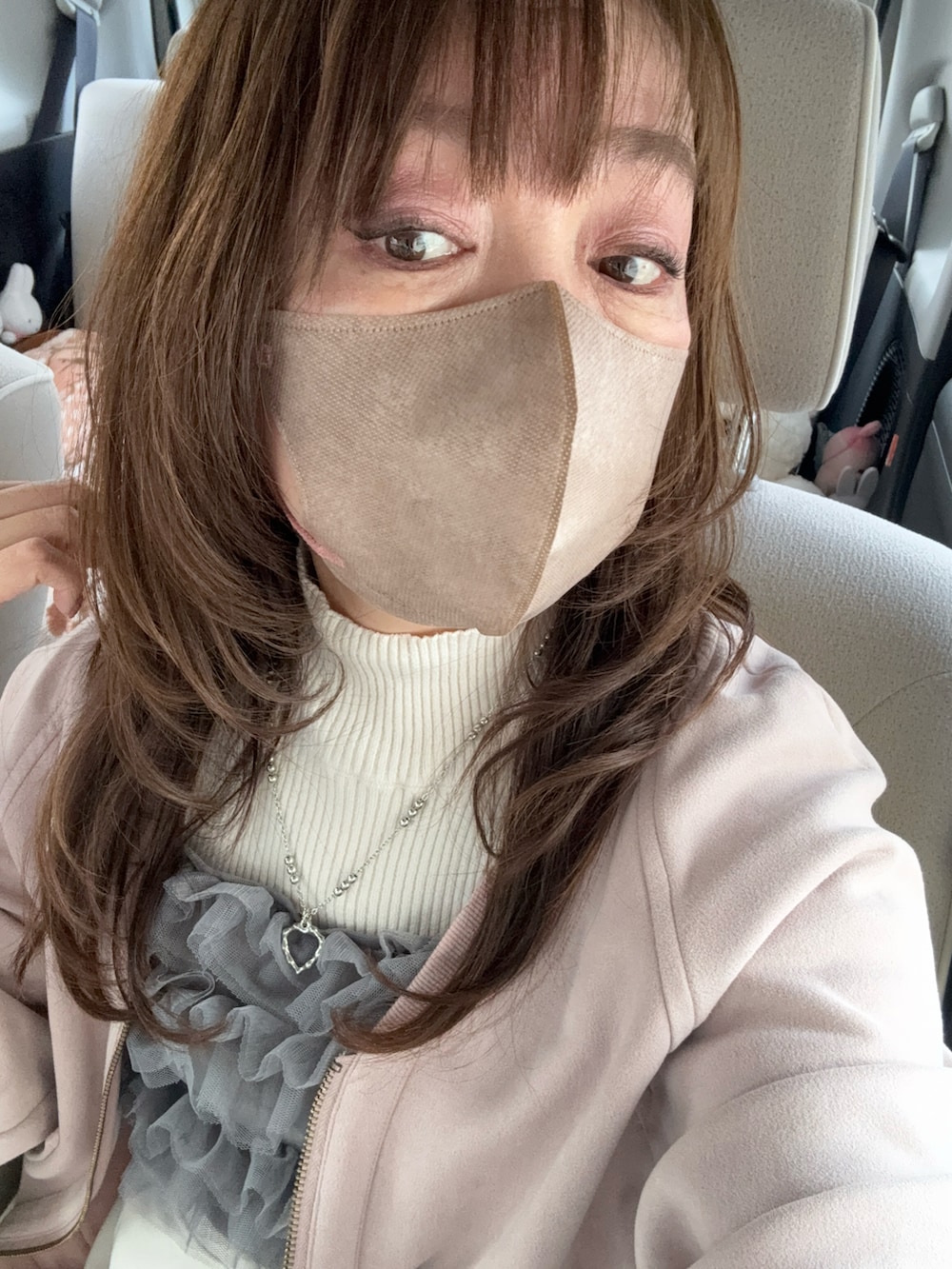 ベージュ系のスカート、ベージュ系のショルダーバッグ、ホワイト系のスニーカーを着用したレディースの冬コーディネートの3枚目の写真