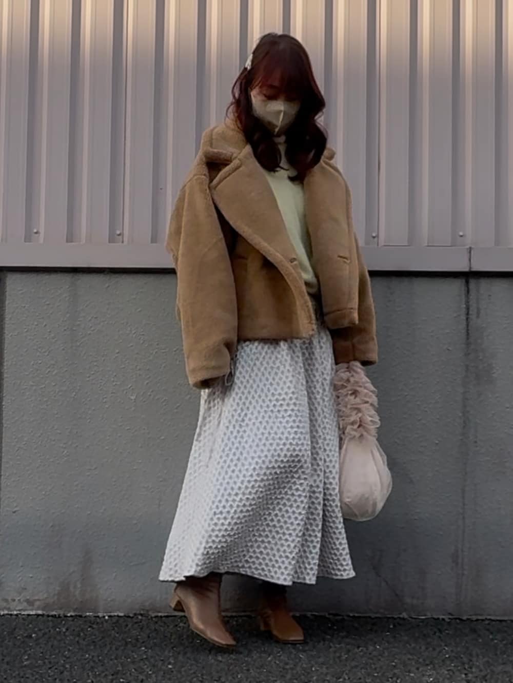 ブラウン系のブーツ、グレー系のスカート、ベージュ系のショルダーバッグを着用したレディースの冬コーディネートの2枚目の写真