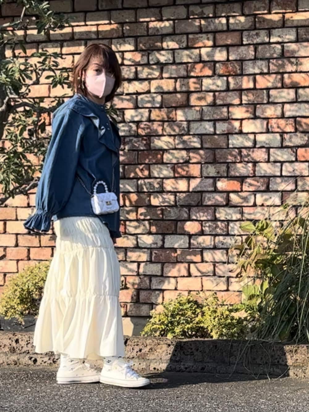 ホワイト系のスカート、ホワイト系のボディバッグ/ウエストポーチ、ホワイト系のスニーカーを着用したレディースの秋コーディネートの2枚目の写真