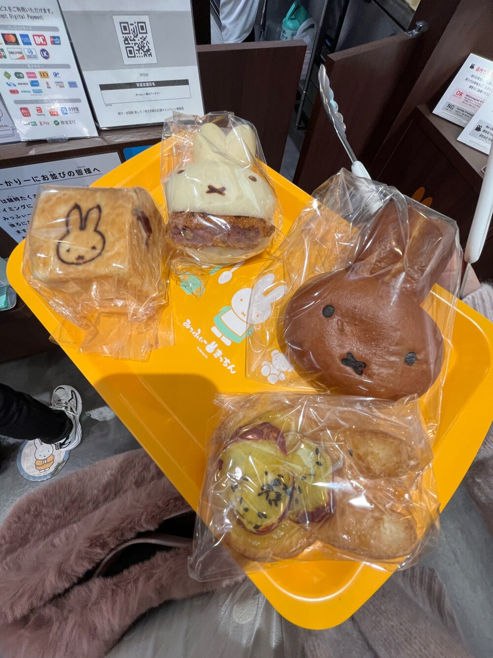 ピンク系のショルダーバッグ、ホワイト系のスカート、ブラック系のブーツを着用したレディースの冬コーディネートの4枚目の写真