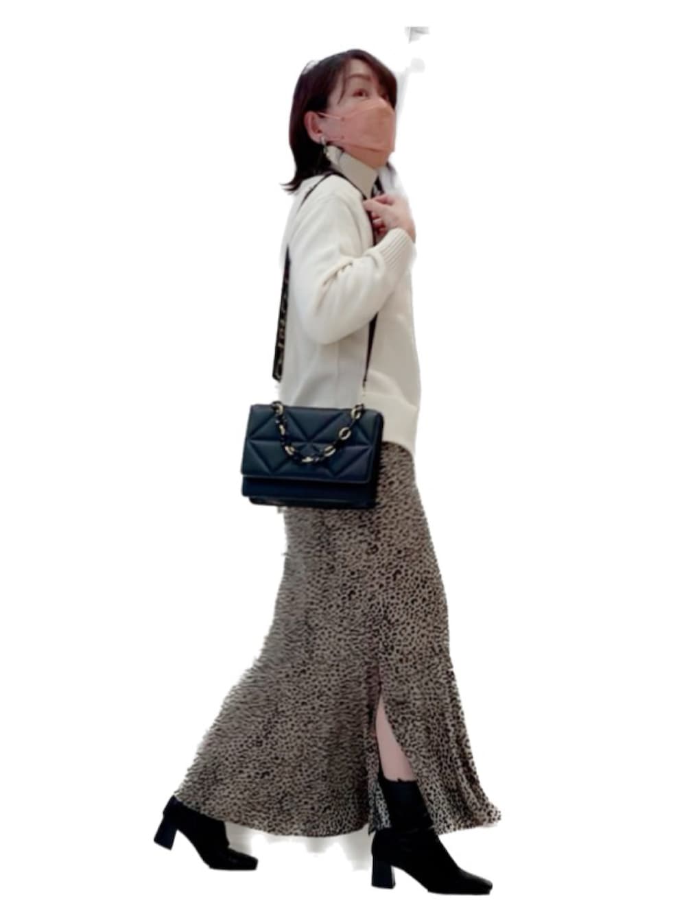 ブラック系のダウンジャケット/コート、ブラック系のショルダーバッグ、ベージュ系のスカートを着用したレディースの冬コーディネートの2枚目の写真