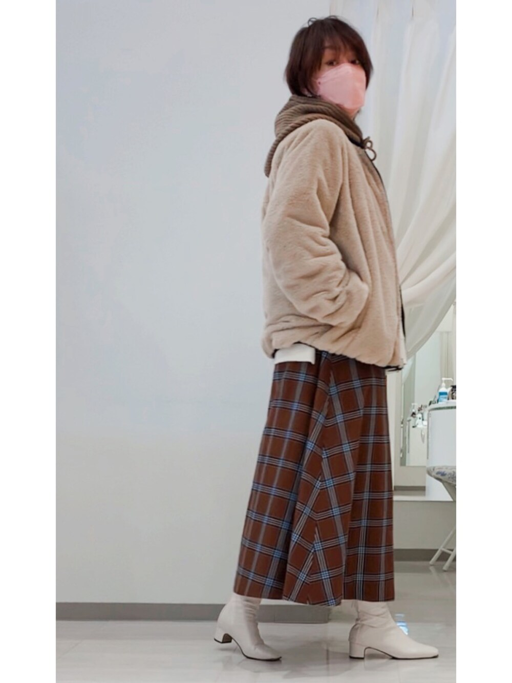 ホワイト系のブーツ、ホワイト系のTシャツ/カットソー、ブラック系のブルゾンを着用したレディースの冬コーディネートの3枚目の写真