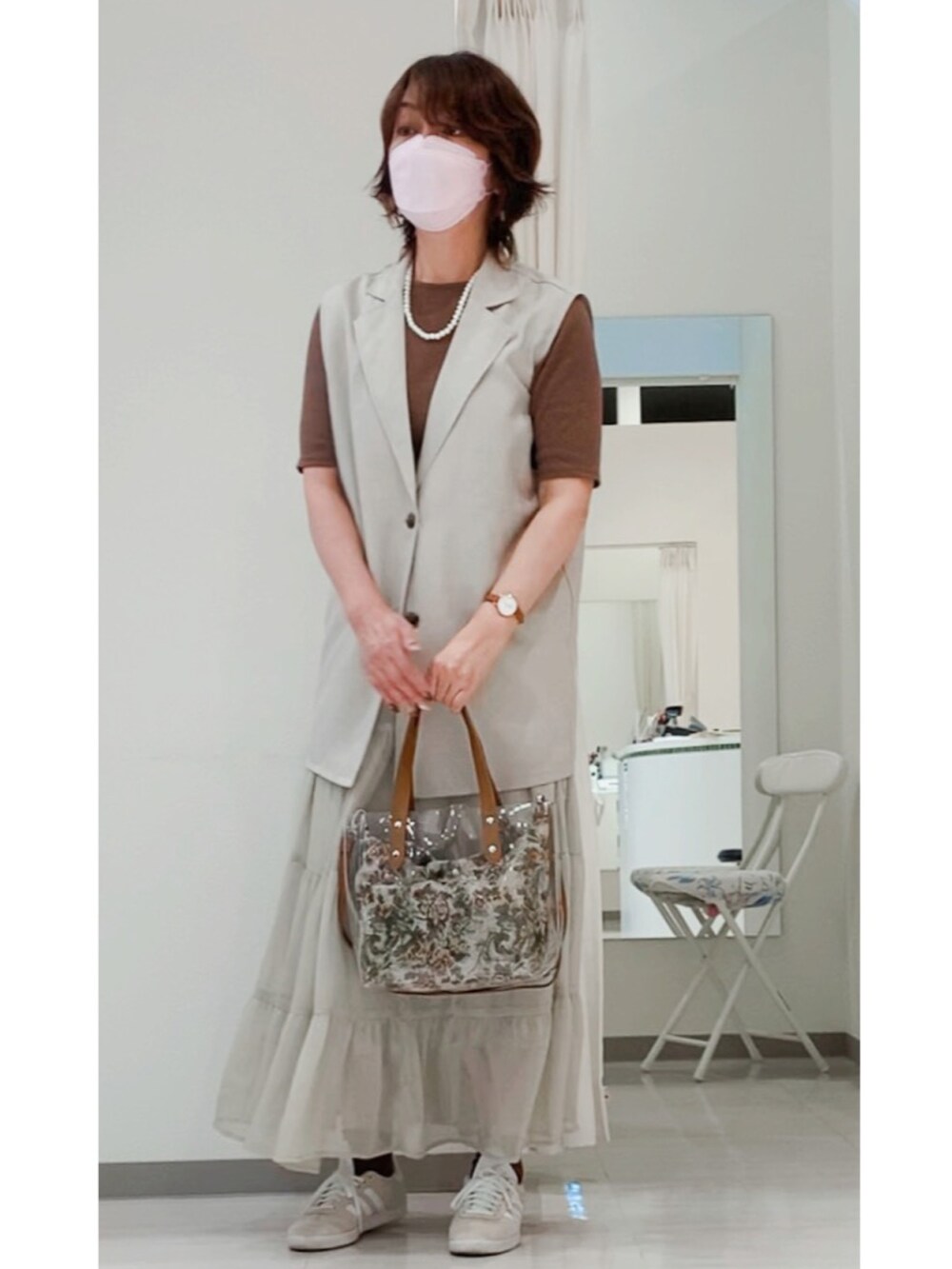 その他のトートバッグ、ベージュ系のスニーカー、ベージュ系のベストを着用したレディースの秋コーディネートの2枚目の写真