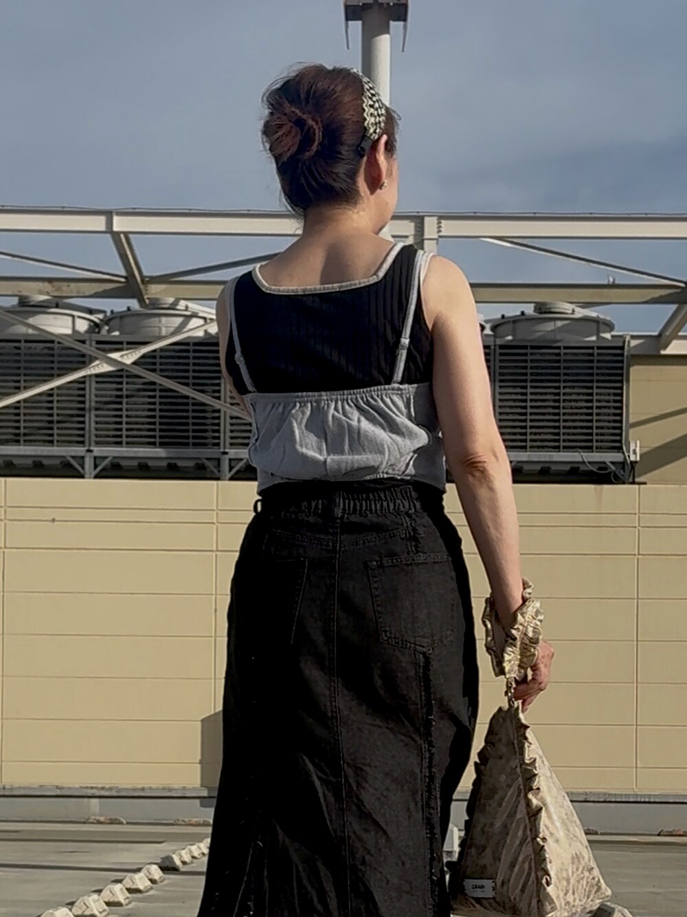 ブラック系のスカート、ピンク系のショルダーバッグ、グレー系のTシャツ/カットソーを着用したレディースの夏コーディネートの2枚目の写真