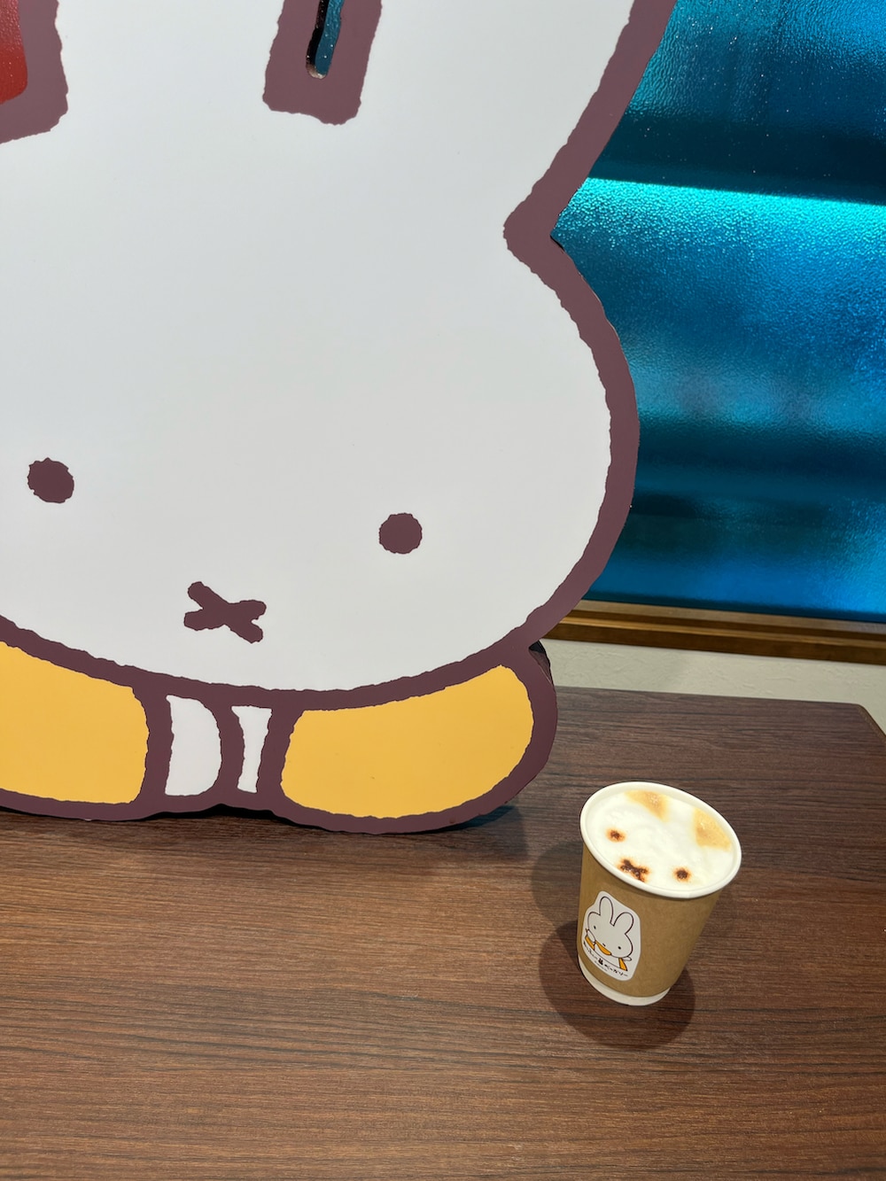 ピンク系のショルダーバッグ、ホワイト系のスカート、ブラック系のブーツを着用したレディースの冬コーディネートの3枚目の写真