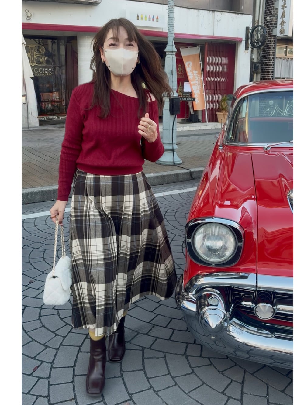 ブラウン系のブーツ、ブラウン系のその他アウター、レッド系のニット/セーターを着用したレディースの秋コーディネートの2枚目の写真