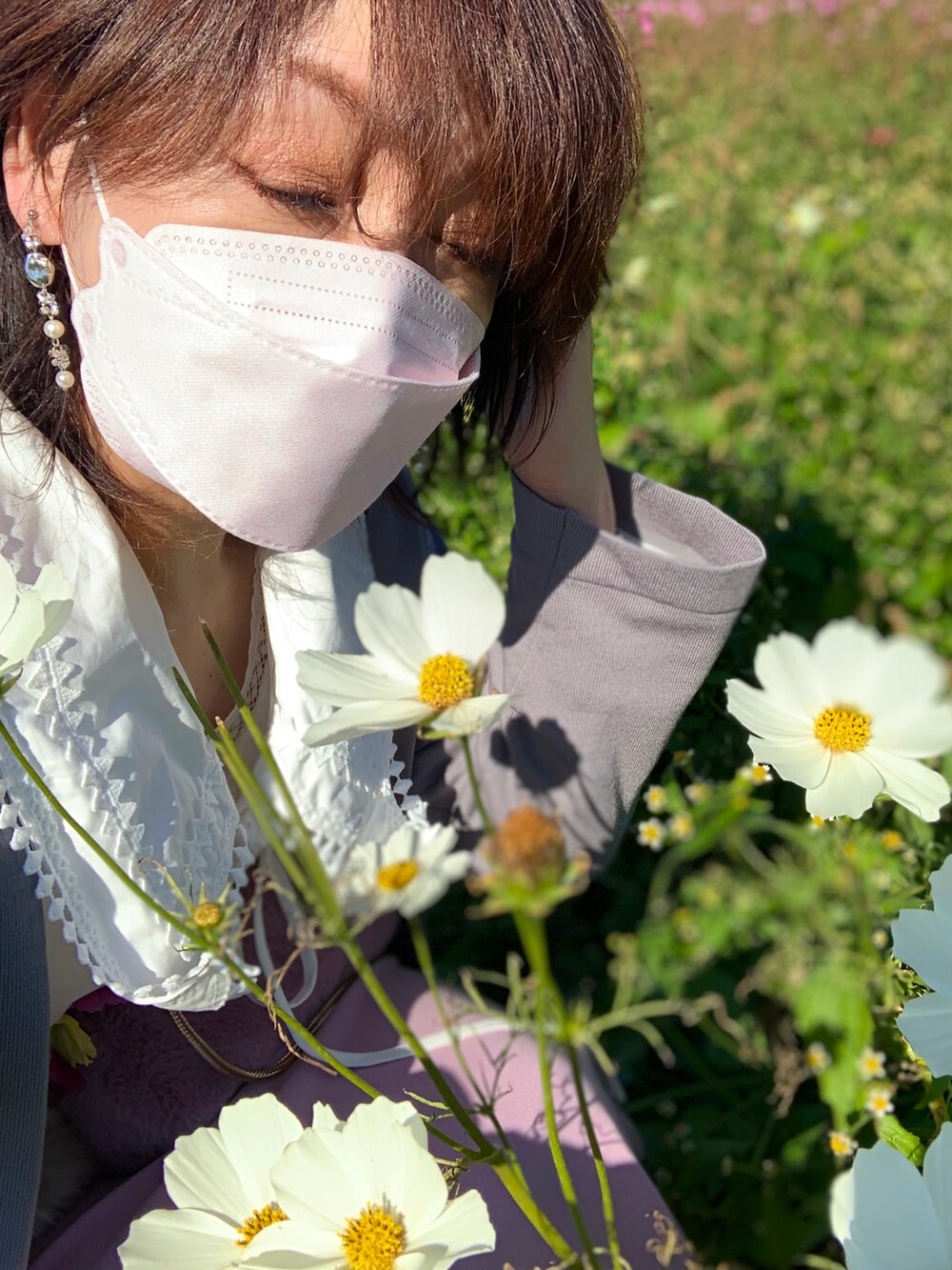 グレー系のカーディガン/ボレロ、ピンク系のスカート、ホワイト系のスニーカーを着用したレディースの秋コーディネートの3枚目の写真