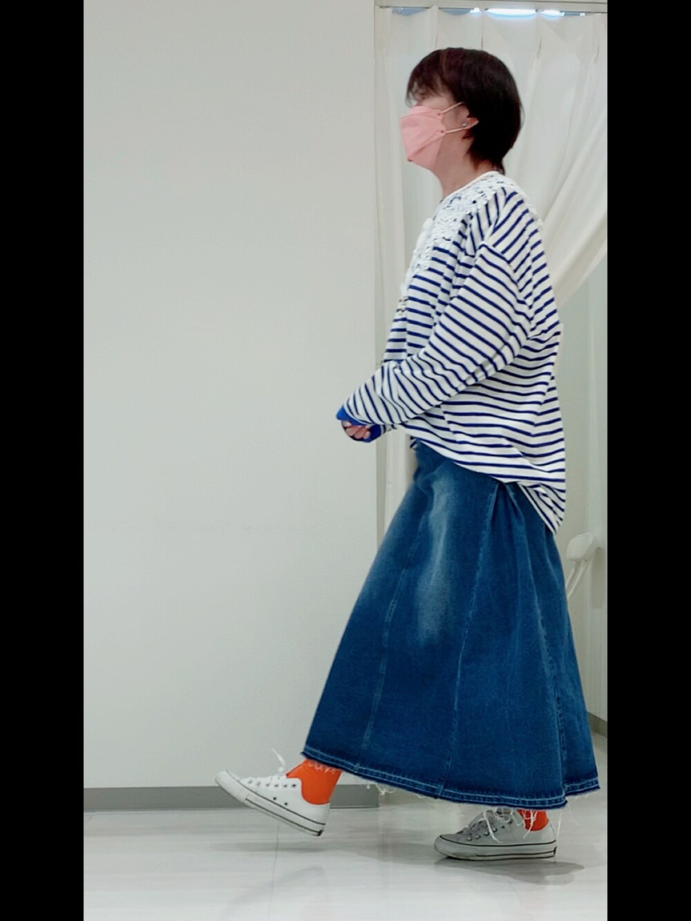 ブルー系のTシャツ/カットソー、ブルー系のデニムスカート、ホワイト系のスニーカーを着用したレディースの春コーディネートの5枚目の写真