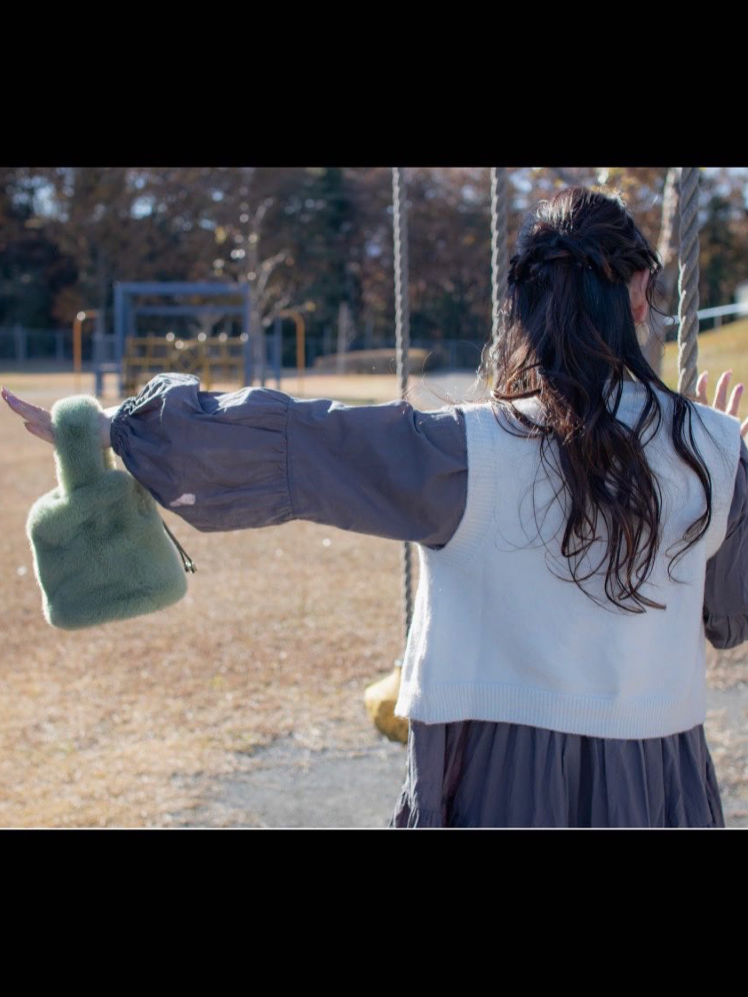 ホワイト系のベスト、グレー系のワンピース、グリーン系のショルダーバッグを着用したレディースの夏コーディネートの3枚目の写真