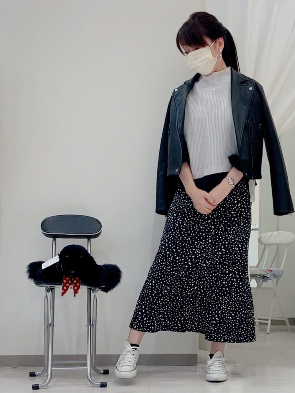 グレー系のベスト、ブラック系のスカート、ホワイト系のスニーカーを着用したレディースの秋コーディネートの2枚目の写真