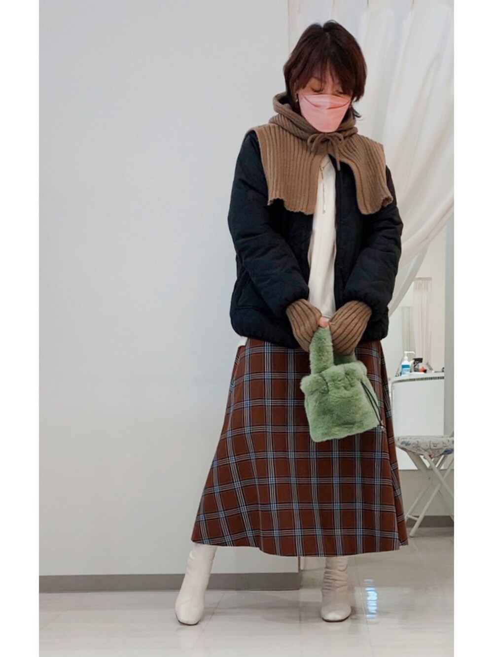 ホワイト系のブーツ、ホワイト系のTシャツ/カットソー、ブラック系のブルゾンを着用したレディースの冬コーディネートの2枚目の写真