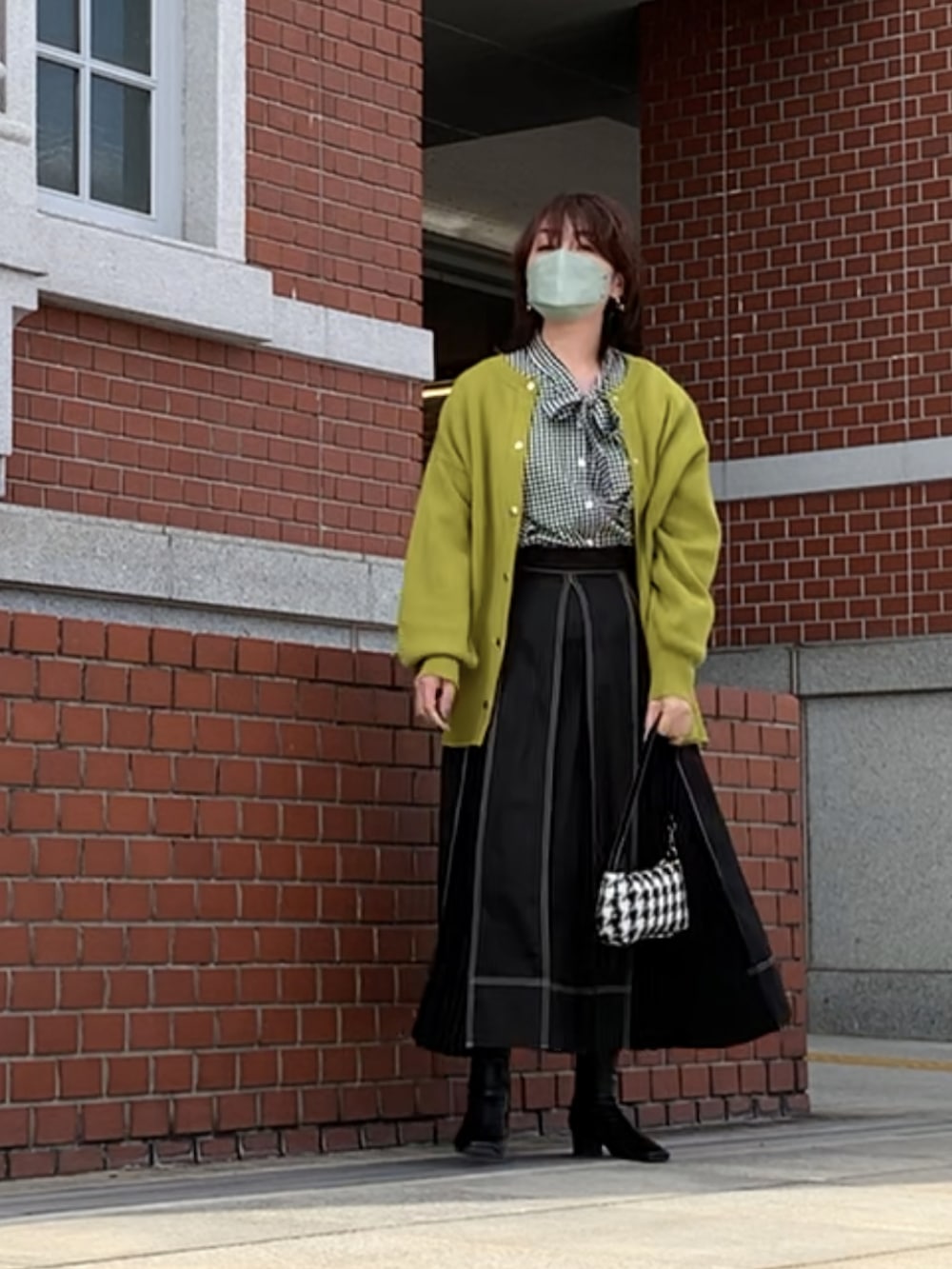 ブラック系のスカート、ブラック系のブーツ、ブラック系のシャツ/ブラウスを着用したレディースの秋コーディネートの3枚目の写真