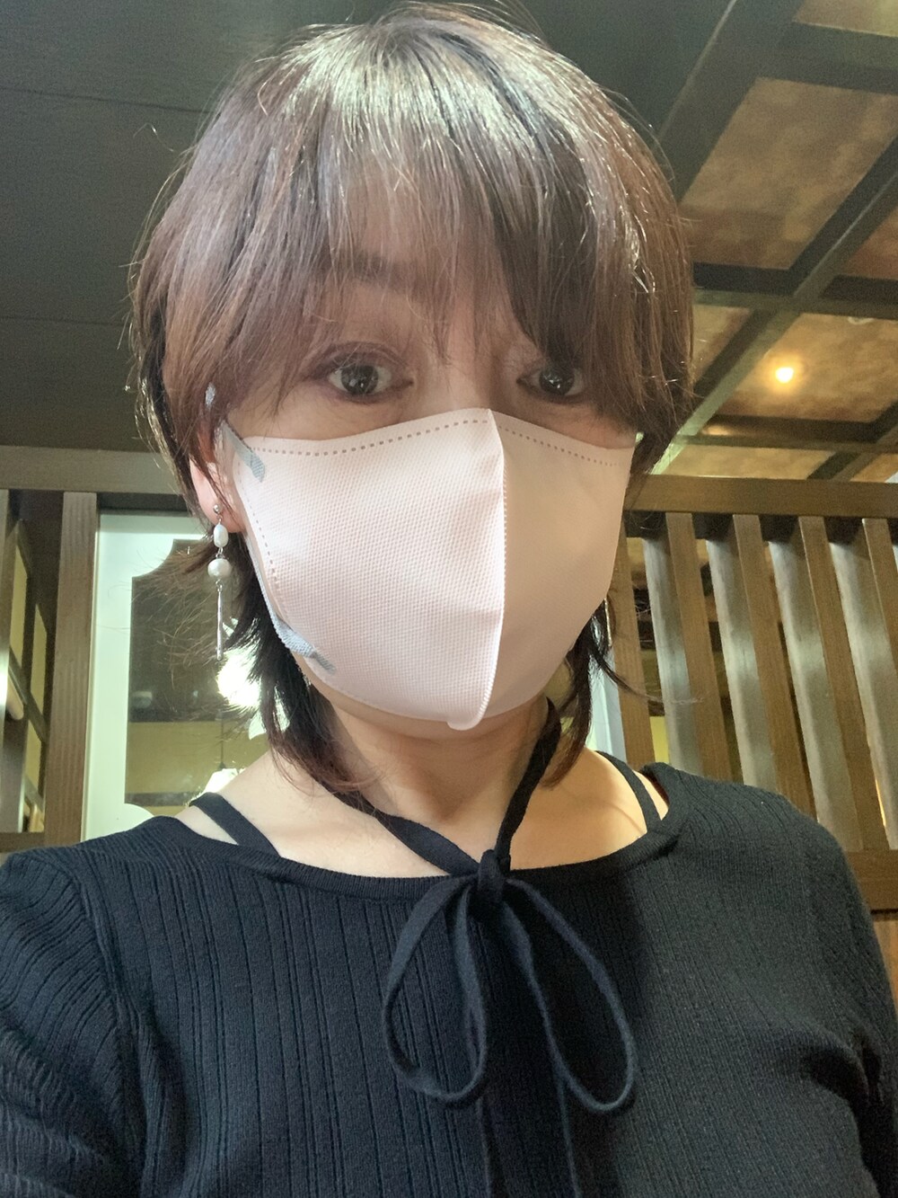 ブラック系のベスト、ホワイト系のスカート、ブラック系のブーツを着用したレディースの秋コーディネートの2枚目の写真