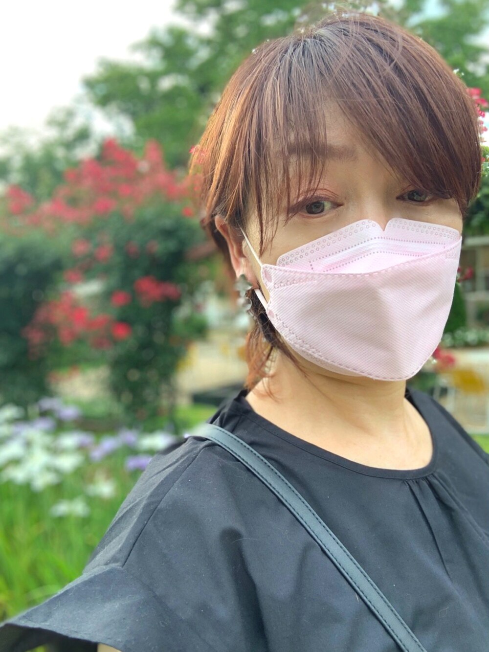 ブラック系のサンダル、ブラウン系のかごバッグ、パープル系のその他を着用したレディースの夏コーディネートの2枚目の写真