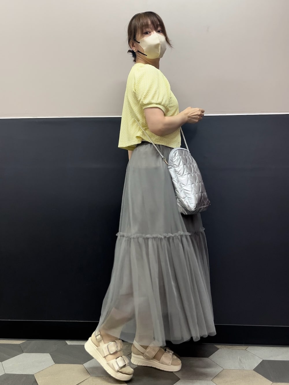 ホワイト系のサンダル、グレー系のスカート、イエロー系のシャツ/ブラウスを着用したレディースの秋コーディネートの3枚目の写真