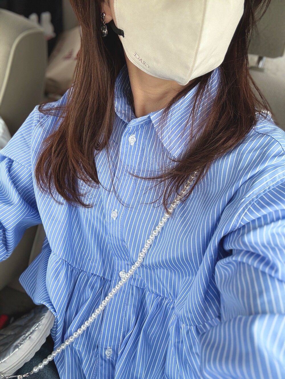 ブルー系のシャツ/ブラウス、シルバー系のショルダーバッグ、ホワイト系のスニーカーを着用したレディースの春コーディネートの2枚目の写真