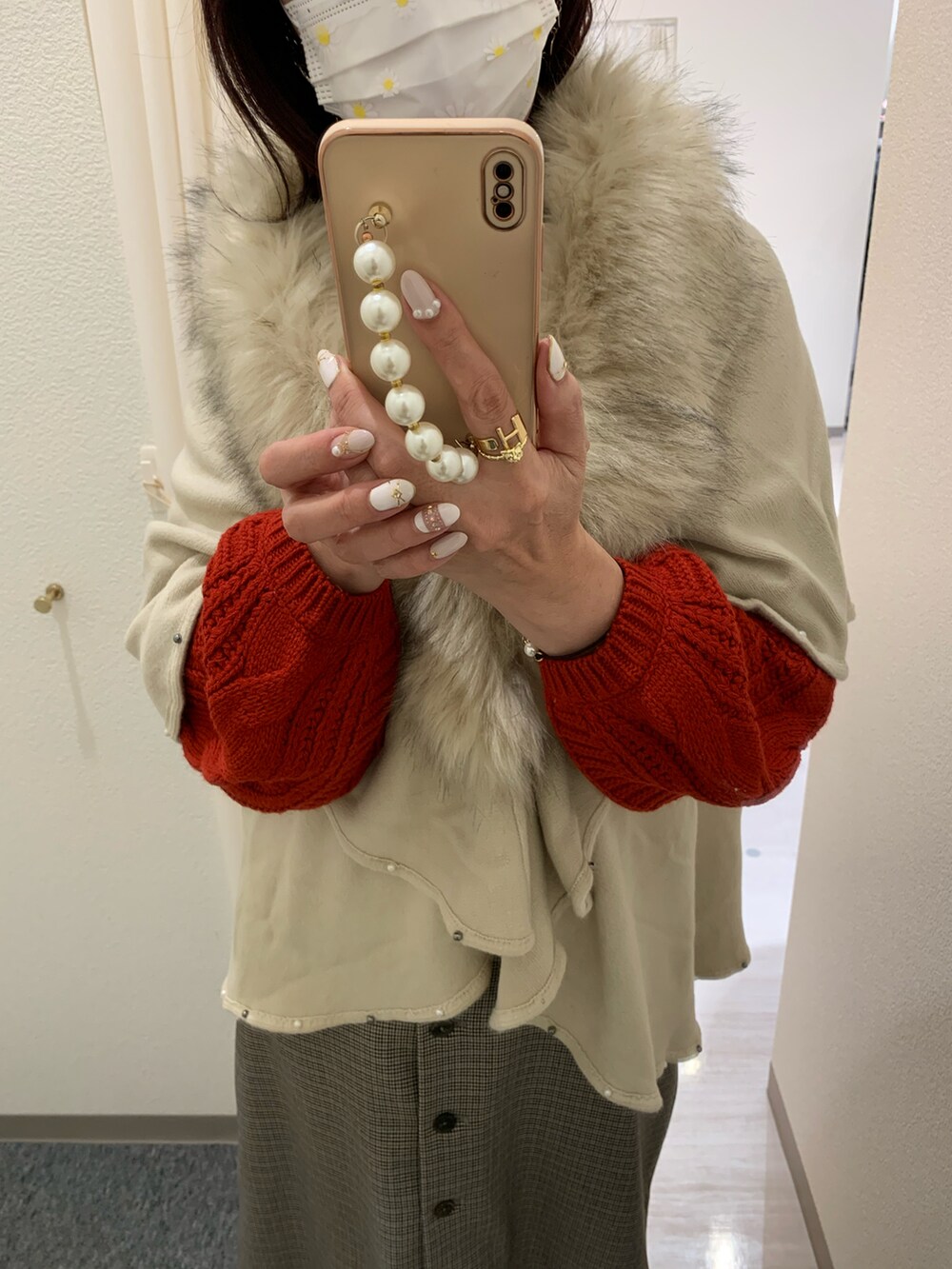 グリーン系のカーディガン/ボレロ、ベージュ系のスカート、ホワイト系のブーツを着用したレディースの冬コーディネートの2枚目の写真