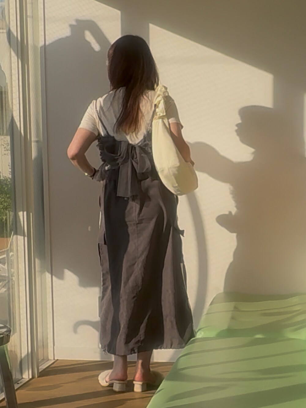 グレー系のキャミソール、ホワイト系のサンダル、グレー系のスカートを着用したレディースの春コーディネートの2枚目の写真