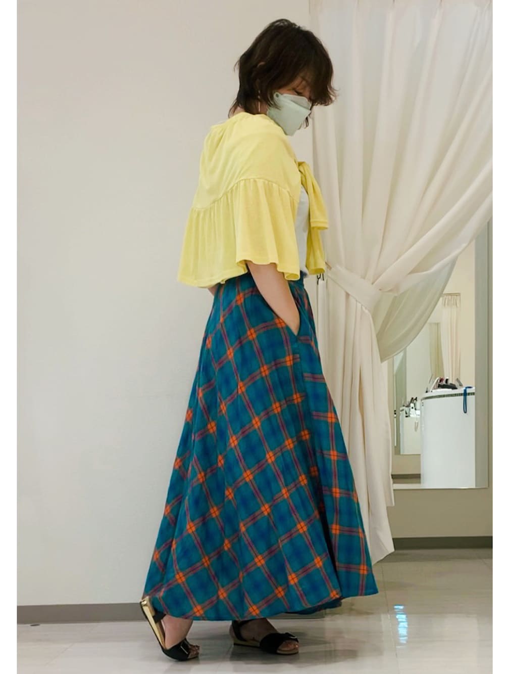 グリーン系のスカート、ブルー系のTシャツ/カットソー、イエロー系のカーディガン/ボレロを着用したレディースの夏コーディネートの2枚目の写真