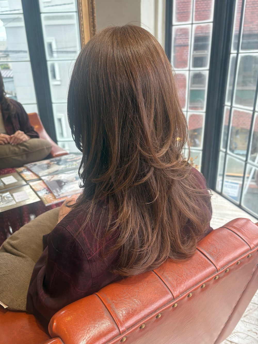 レッド系のシャツ/ブラウス、レッド系のスカート、ブラック系のショルダーバッグを着用したレディースの秋コーディネートの3枚目の写真