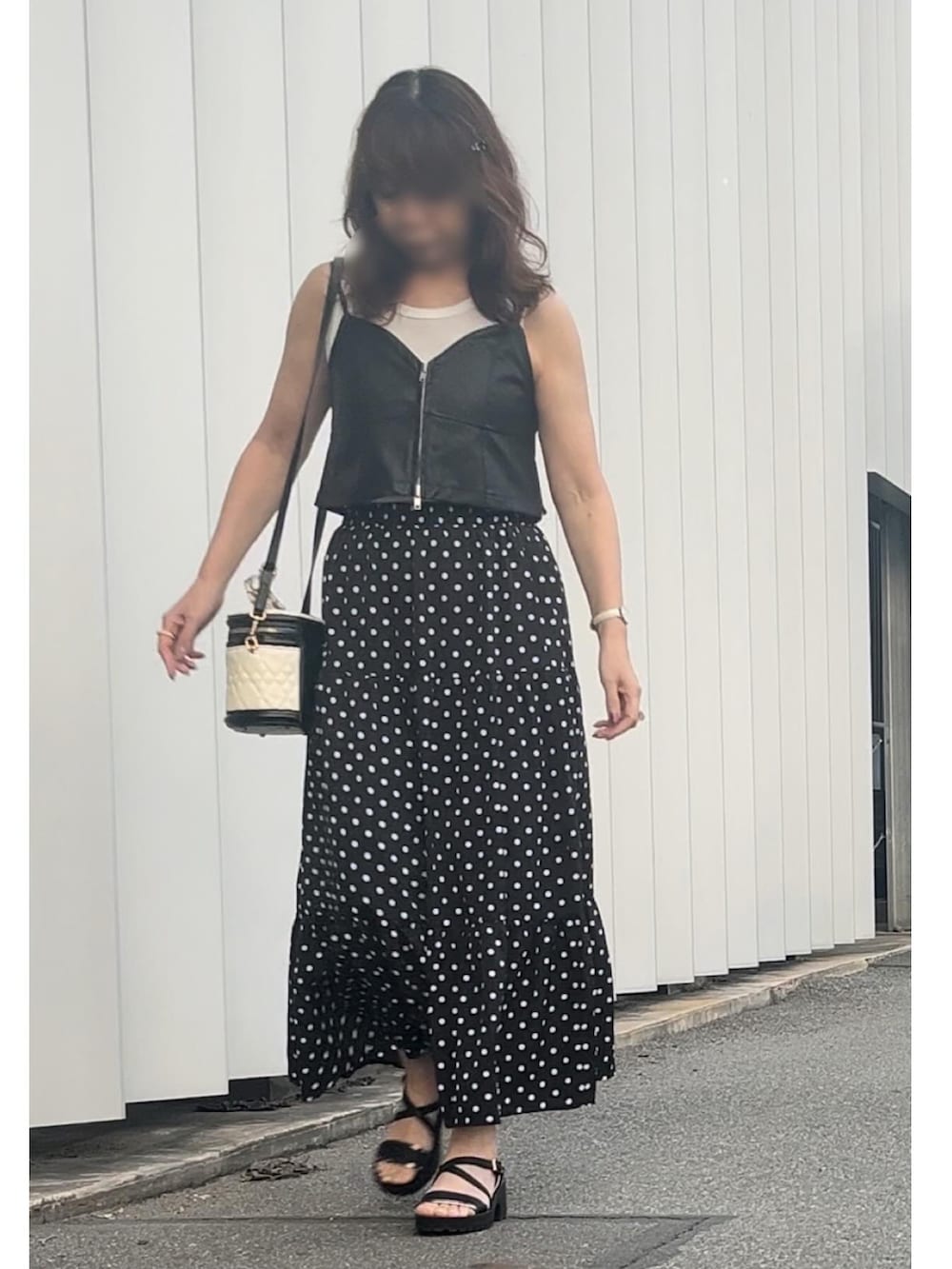 その他のキャミソール、ブラック系のスカート、ホワイト系のショルダーバッグを着用したレディースの秋コーディネートの2枚目の写真