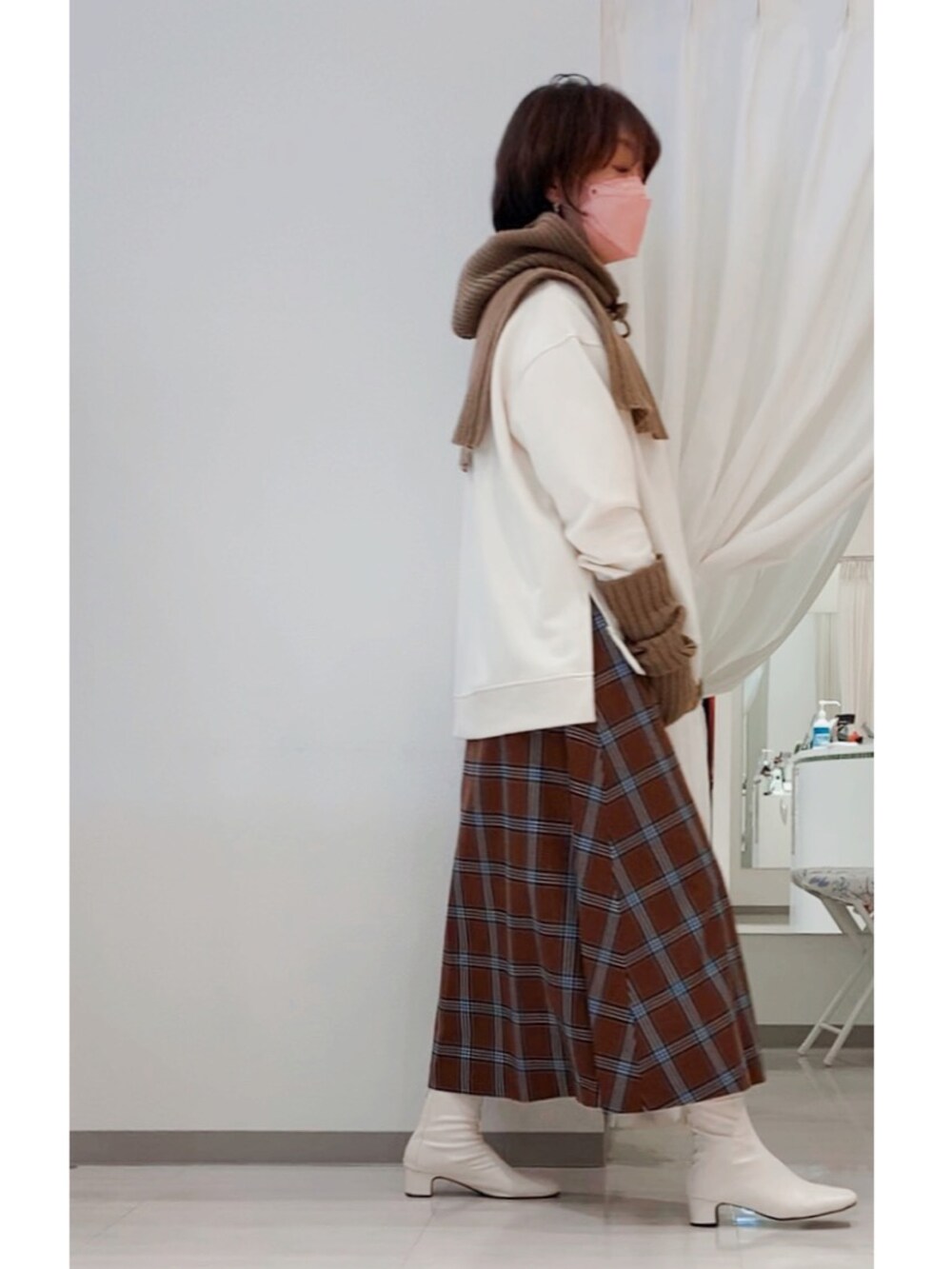 ホワイト系のブーツ、ホワイト系のTシャツ/カットソー、ブラック系のブルゾンを着用したレディースの冬コーディネートの4枚目の写真