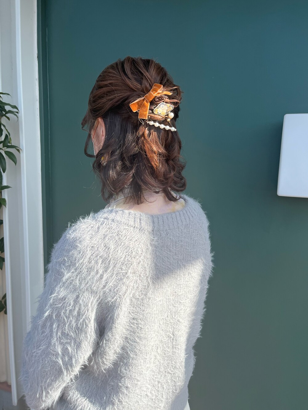 ホワイト系のショルダーバッグ、ホワイト系のスカート、グレー系のカーディガン/ボレロを着用したレディースの冬コーディネートの5枚目の写真