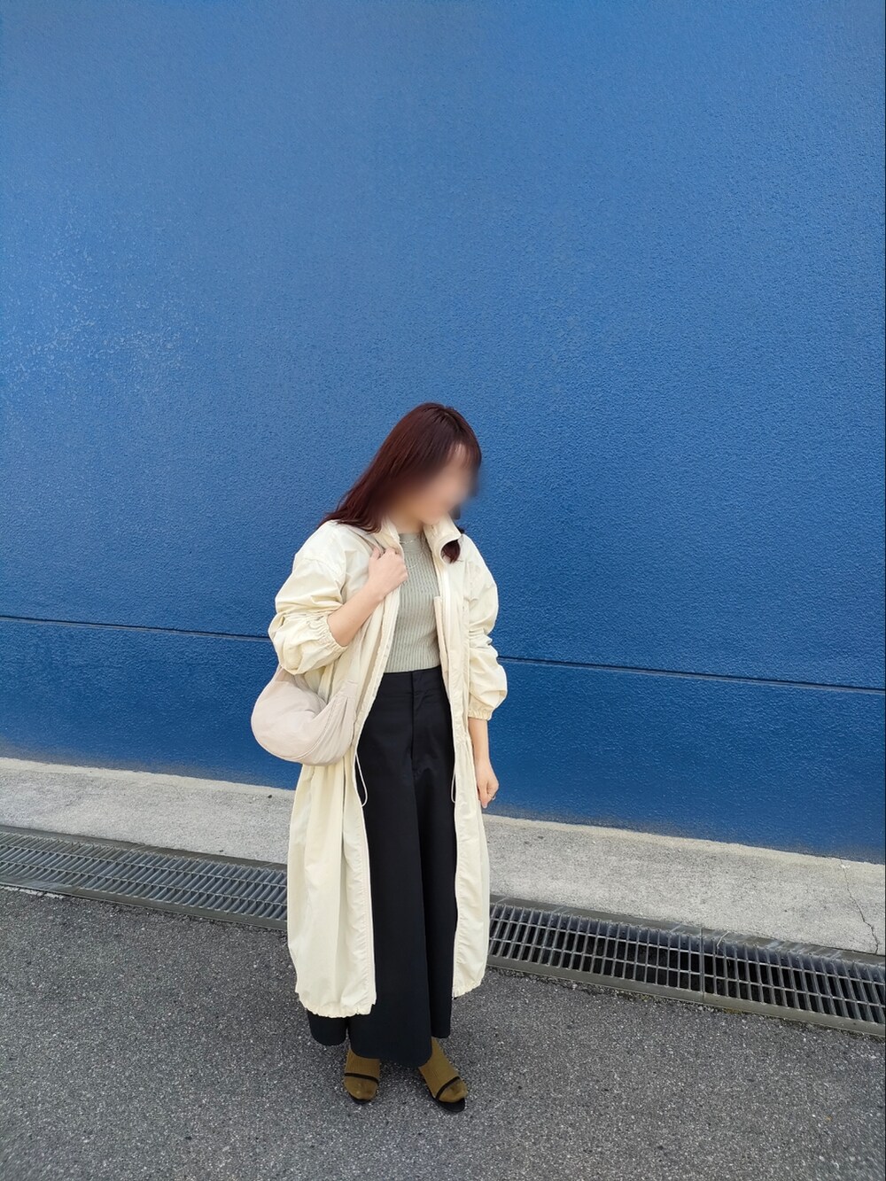 ホワイト系のショルダーバッグ、グリーン系のTシャツ/カットソー、ブラック系のスカートを着用したレディースの春コーディネートの2枚目の写真