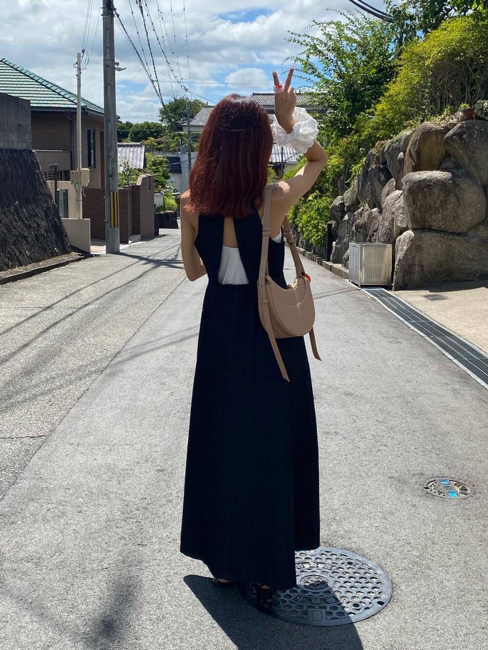 ブルー系のワンピース/ドレス、ブラック系のサンダル、ベージュ系のショルダーバッグを着用したレディースの夏コーディネートの3枚目の写真