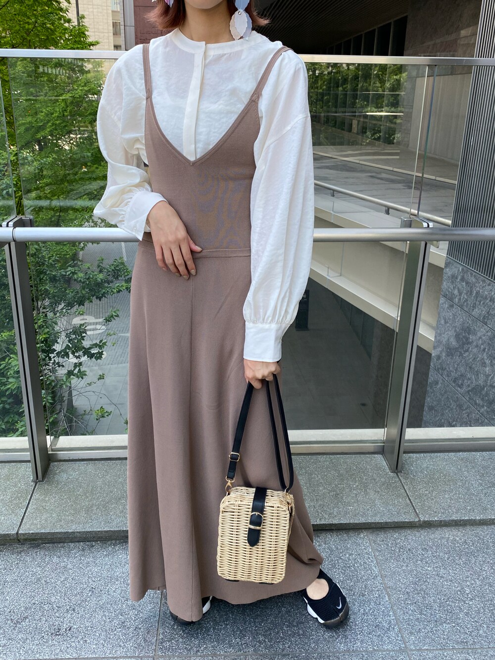 ベージュ系のワンピース、ブラック系のスニーカー、ホワイト系のシャツ/ブラウスを着用したレディースの春コーディネートの3枚目の写真