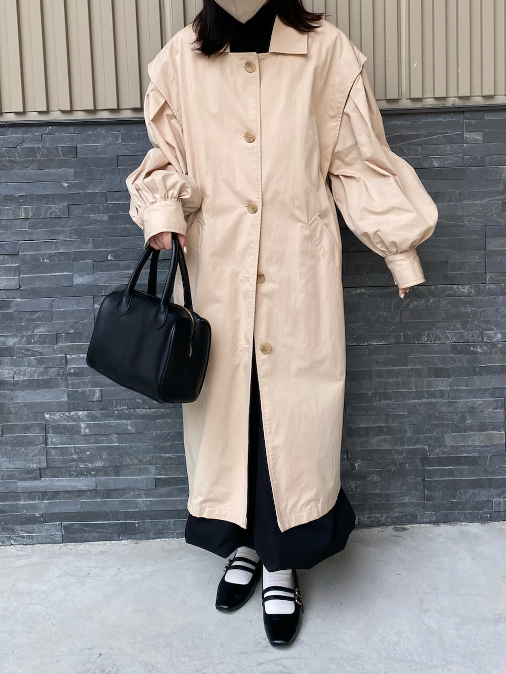 ブラック系のバレエシューズ、ブラック系のショルダーバッグ、ベージュ系のトレンチコートを着用したレディースの春コーディネートの2枚目の写真