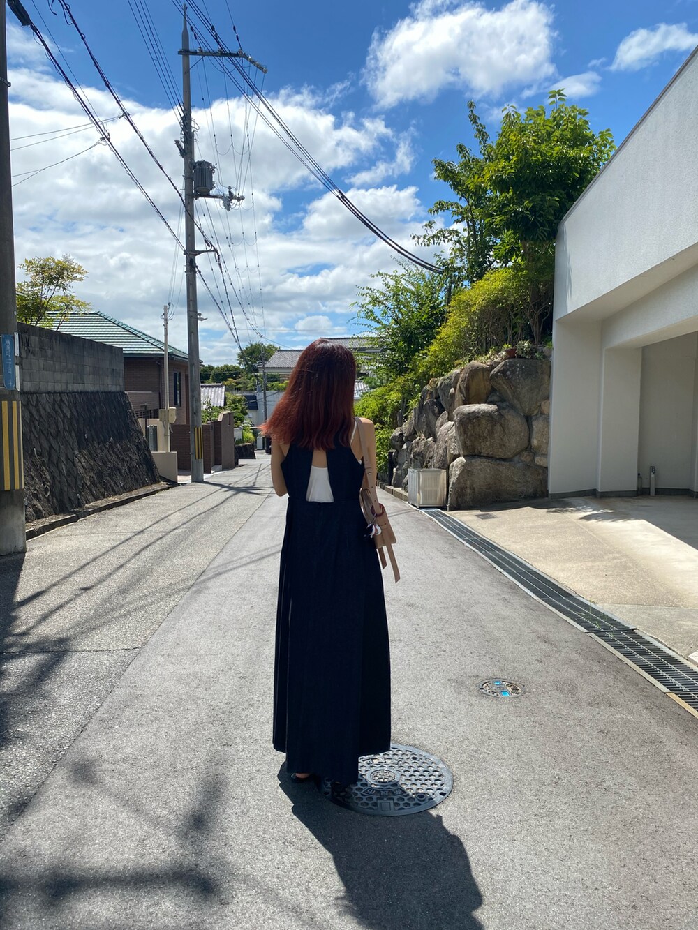 ブルー系のワンピース/ドレス、ブラック系のサンダル、ベージュ系のショルダーバッグを着用したレディースの夏コーディネートの2枚目の写真