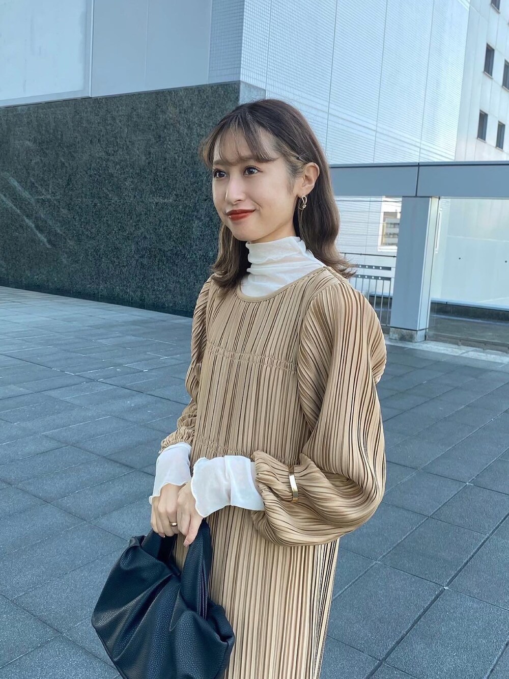 ベージュ系のワンピース/ドレス、ホワイト系のブーツ、ブラック系のショルダーバッグを着用したレディースの秋コーディネートの2枚目の写真