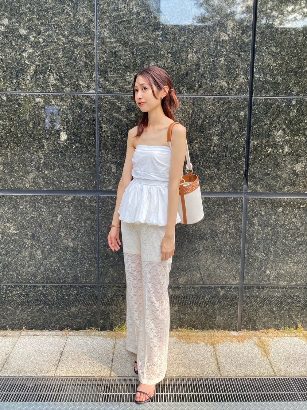 ホワイト系のパンツ、ブラック系のサンダルを着用したレディースの夏コーディネートの2枚目の写真