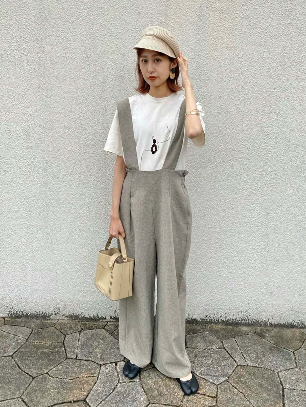 ベージュ系のショルダーバッグ、ブラウン系のパンツ、イエロー系のTシャツ/カットソーを着用したレディースの春コーディネートの2枚目の写真