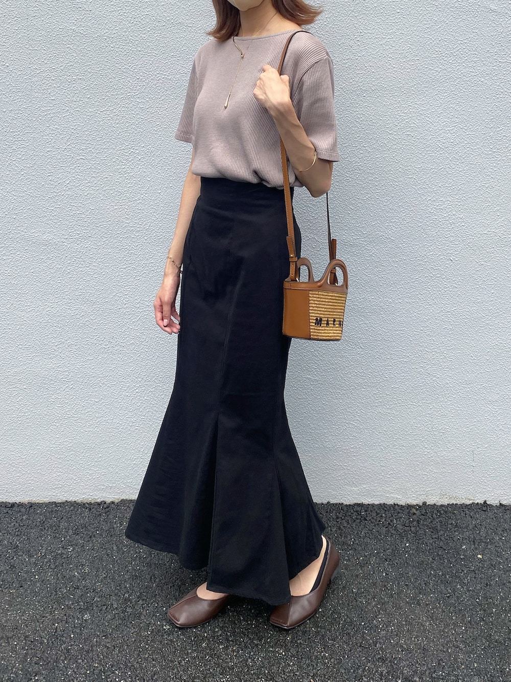 ブラウン系のTシャツ/カットソー、ブラック系のスカート、ブラウン系のパンプスを着用したレディースの夏コーディネートの2枚目の写真