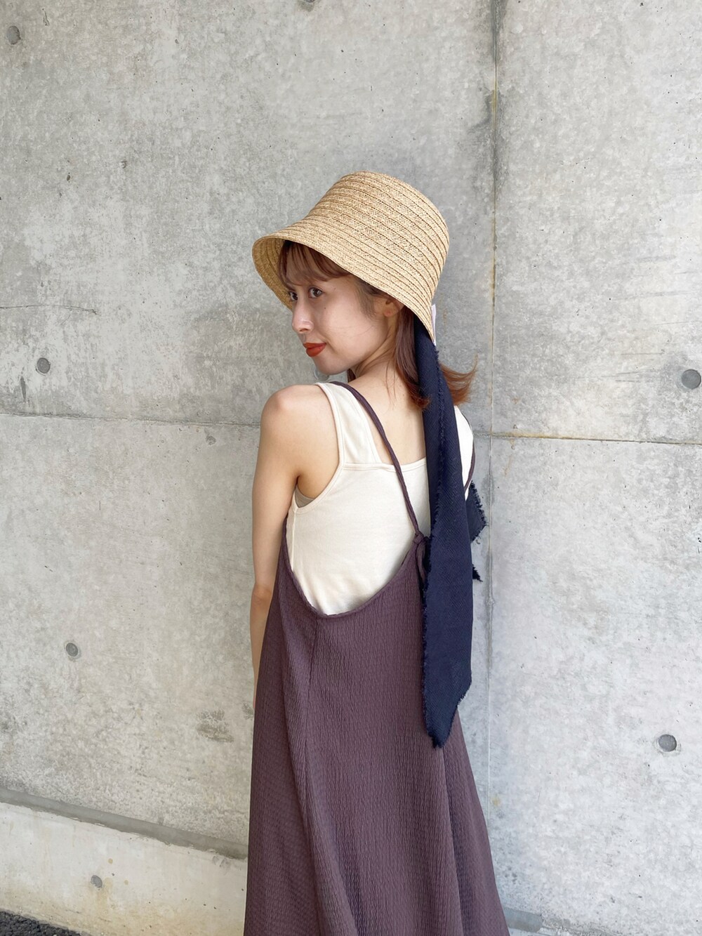 ブラウン系のワンピース、ベージュ系のサンダル、ベージュ系のハットを着用したレディースの夏コーディネートの3枚目の写真