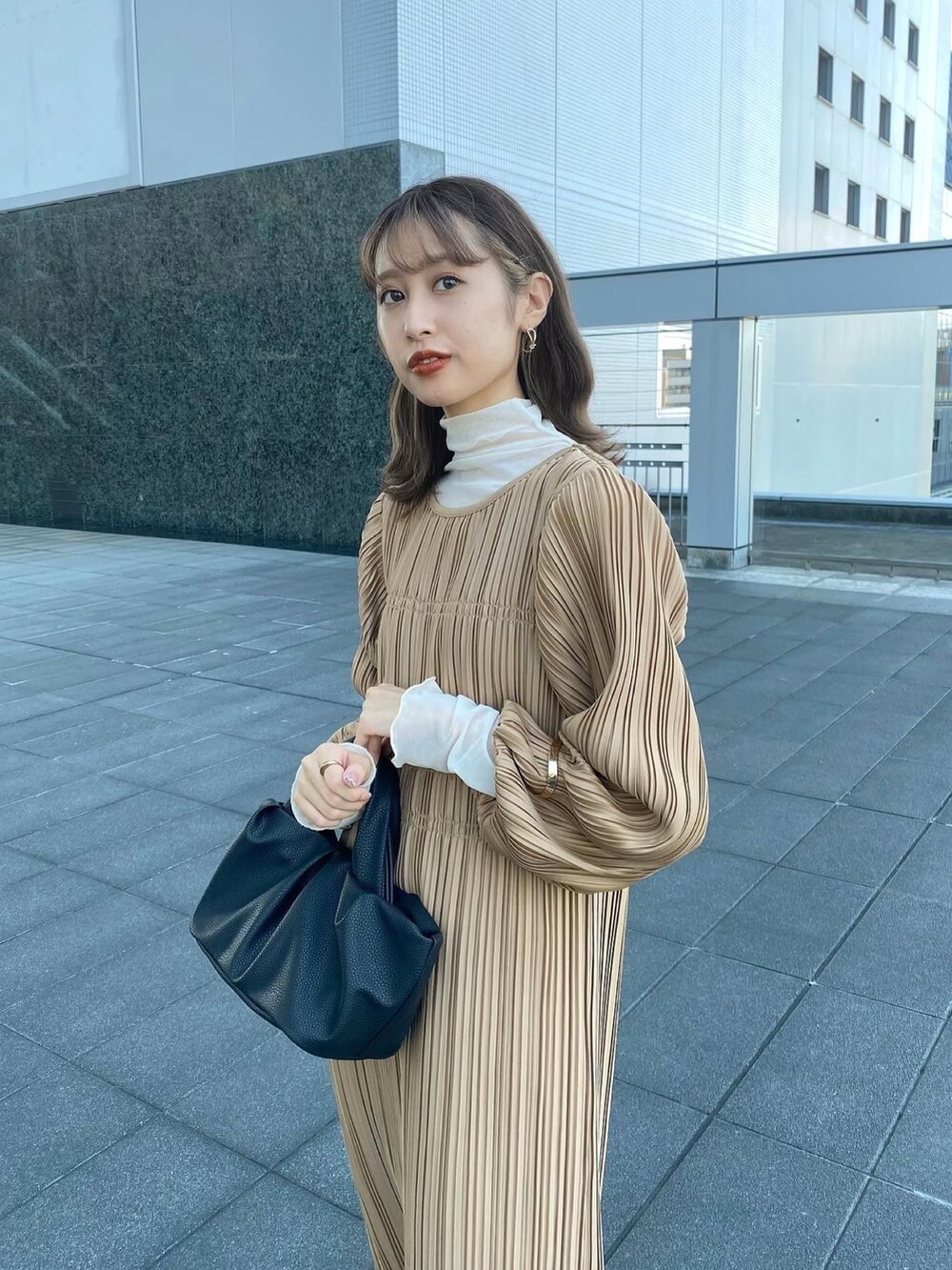 ベージュ系のワンピース/ドレス、ホワイト系のブーツ、ブラック系のショルダーバッグを着用したレディースの秋コーディネートの3枚目の写真