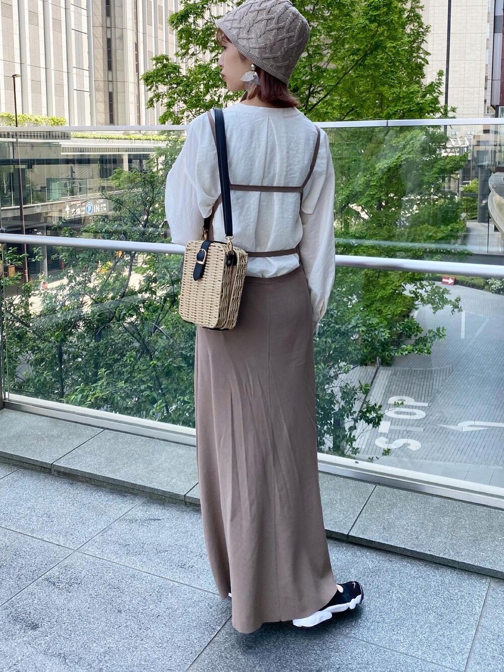 ベージュ系のワンピース、ブラック系のスニーカー、ホワイト系のシャツ/ブラウスを着用したレディースの春コーディネートの2枚目の写真