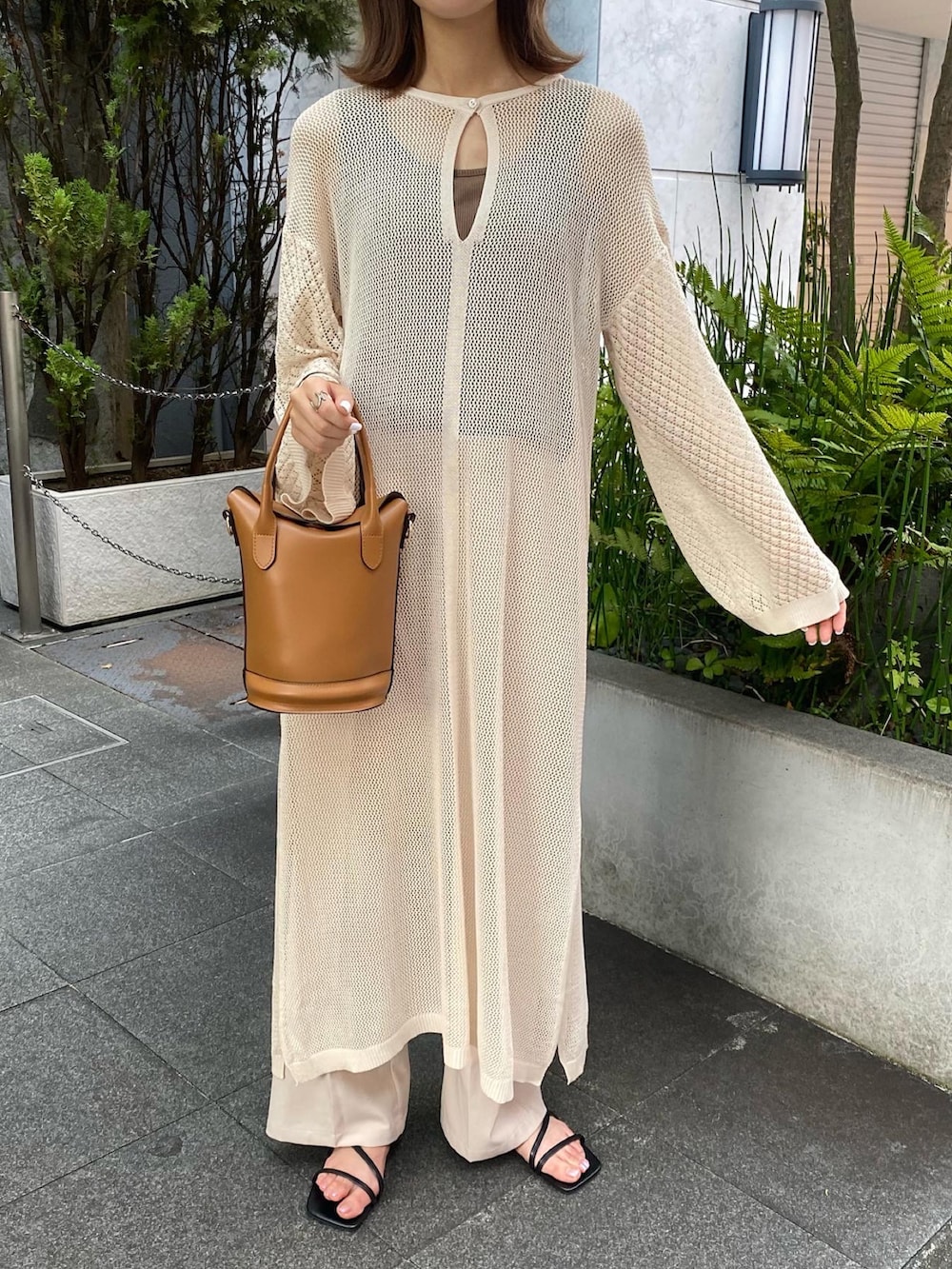 ベージュ系のワンピース、ブラック系のサンダル、ブラウン系のショルダーバッグを着用したレディースの夏コーディネートの3枚目の写真