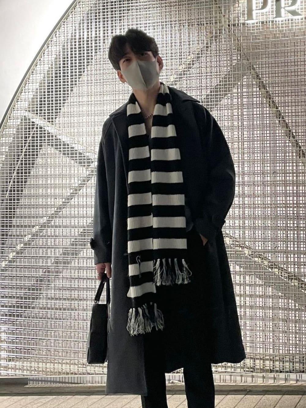 ブラック系のハンドバッグ、その他のマフラーを着用したメンズの冬コーディネートの2枚目の写真