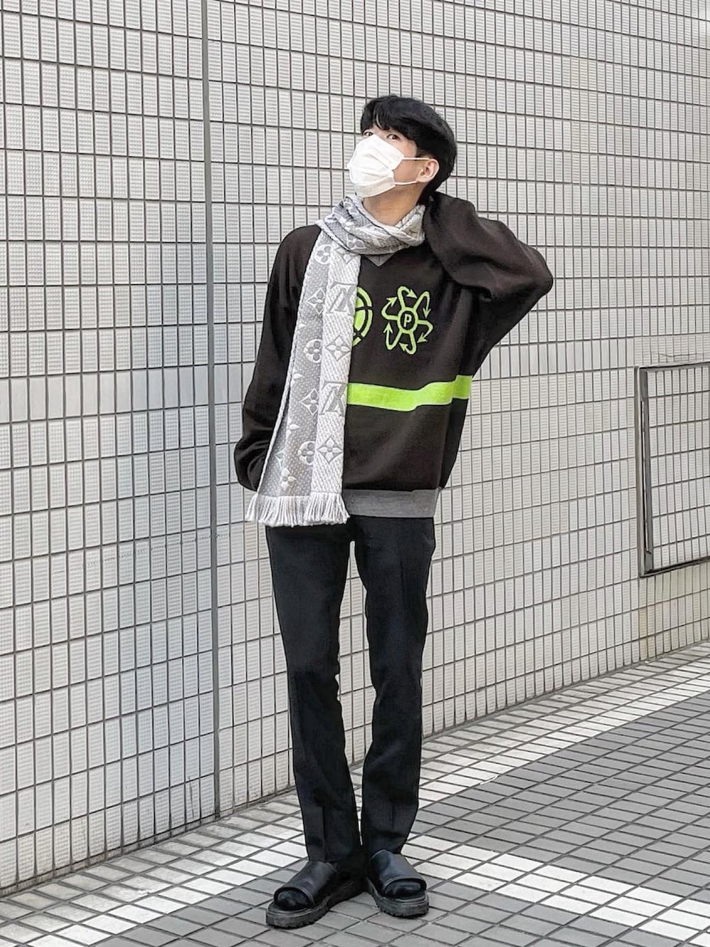 ブラウン系のニット/セーター、ブラック系のサンダル、グレー系のマフラーを着用したメンズの冬コーディネートの2枚目の写真