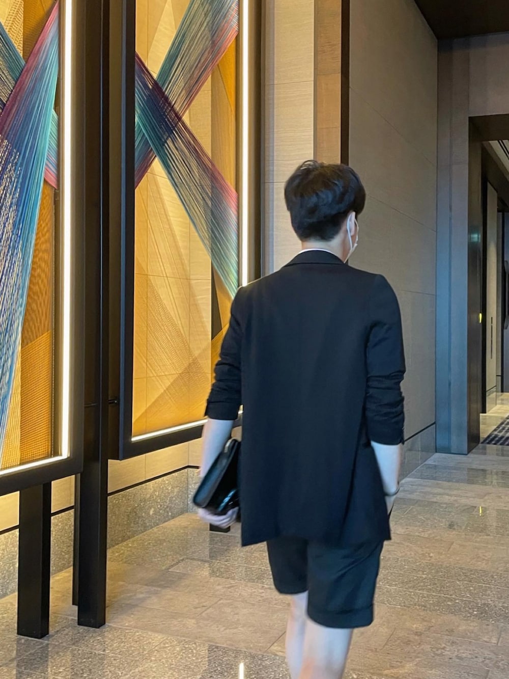 ブラック系のテーラードジャケット、ピンク系のポロシャツ、ブラック系のローファーを着用したメンズの夏コーディネートの2枚目の写真