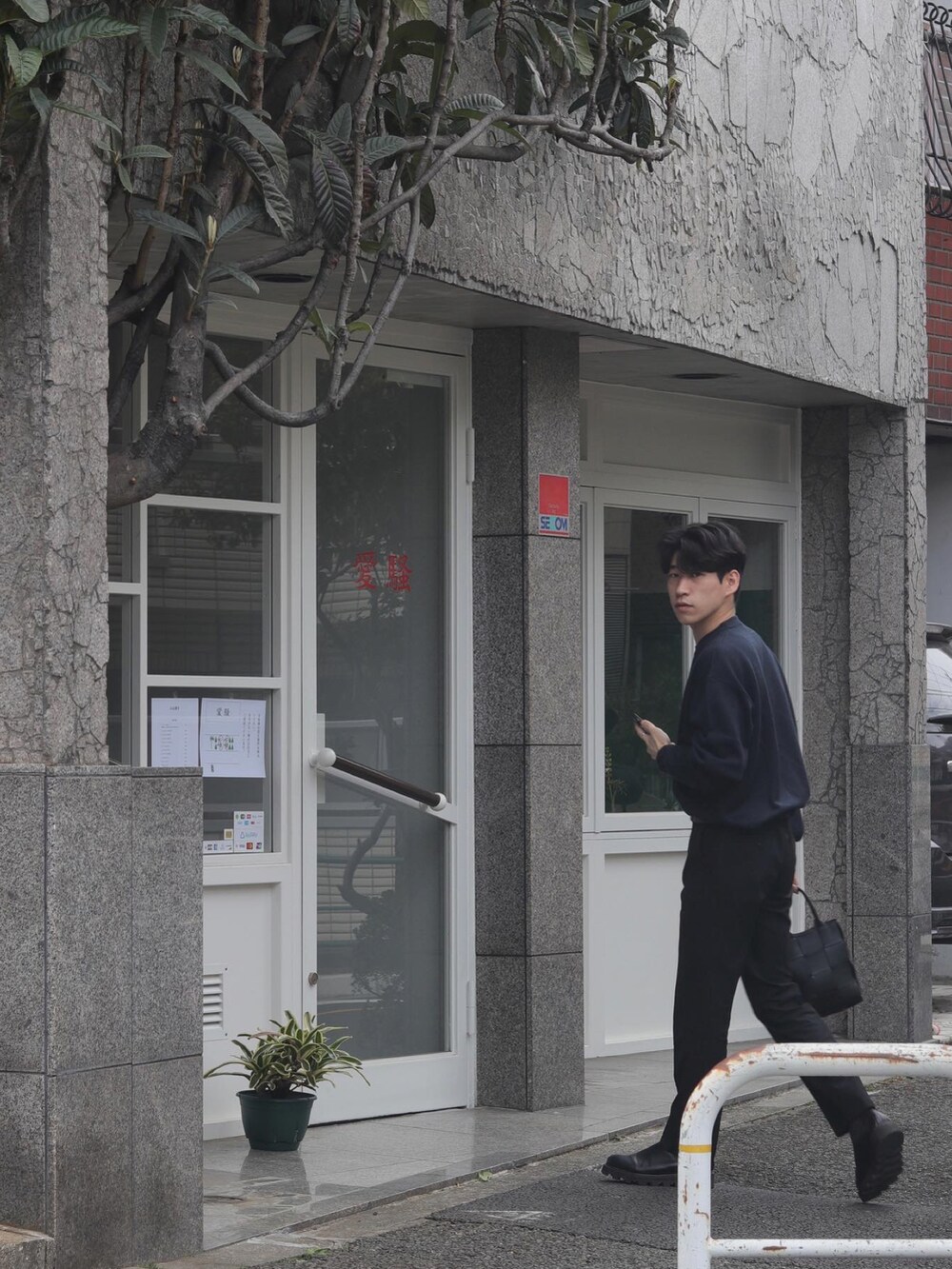 ブラック系のハンドバッグ、シルバー系のリングを着用したメンズの春コーディネートの2枚目の写真