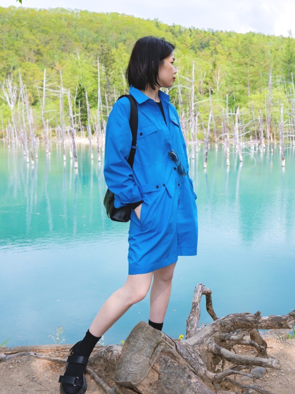 ブラック系のバッグ、ブルー系のワンピース、ブラック系のサンダルを着用したレディースの夏コーディネートの2枚目の写真