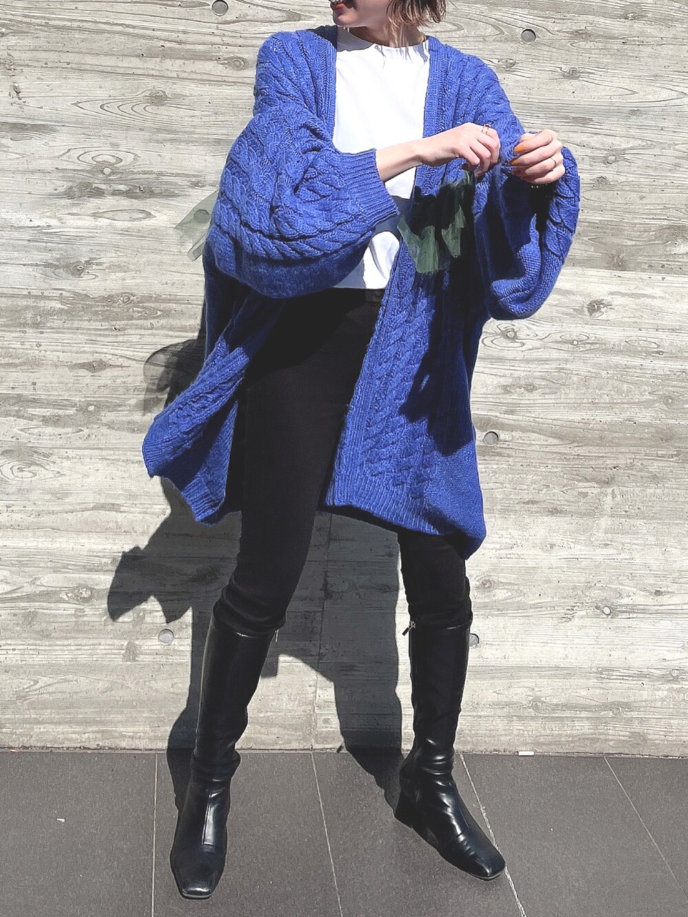 ブルー系のカーディガン/ボレロ、ブラック系のブーツ、ブラック系のパンツを着用したレディースの春コーディネートの3枚目の写真