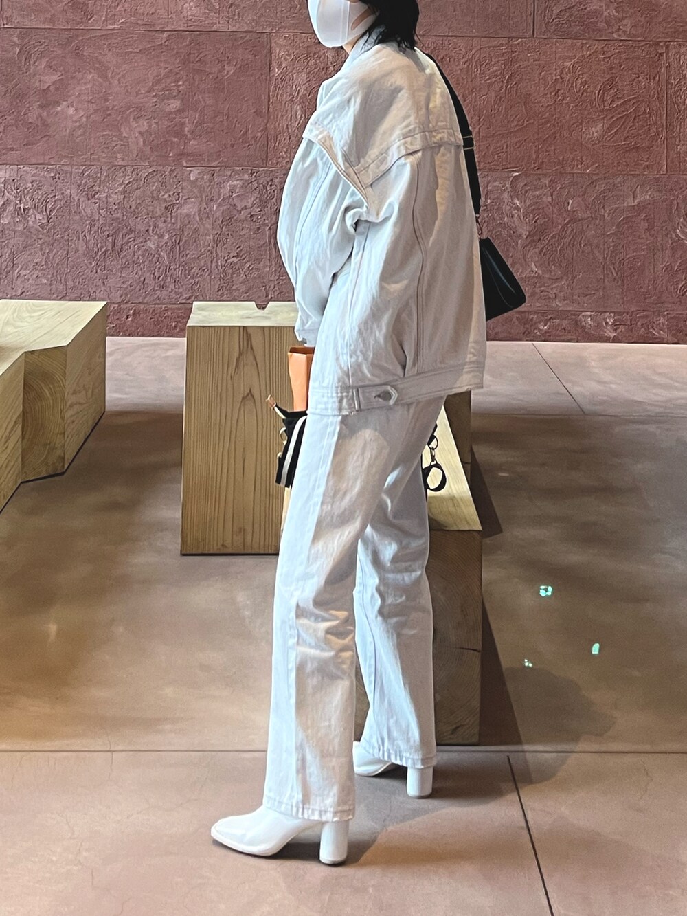 ホワイト系のデニムパンツ、ホワイト系のデニムジャケット、ホワイト系のブーツを着用したレディースの春コーディネートの2枚目の写真