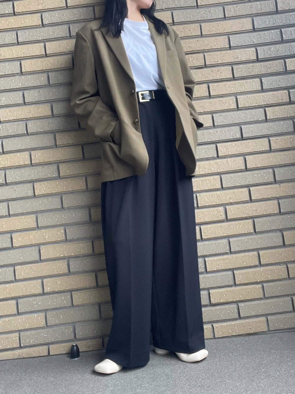 グリーン系のテーラードジャケット、ブラック系のその他パンツ、ホワイト系のサンダルを着用したレディースの秋コーディネートの2枚目の写真